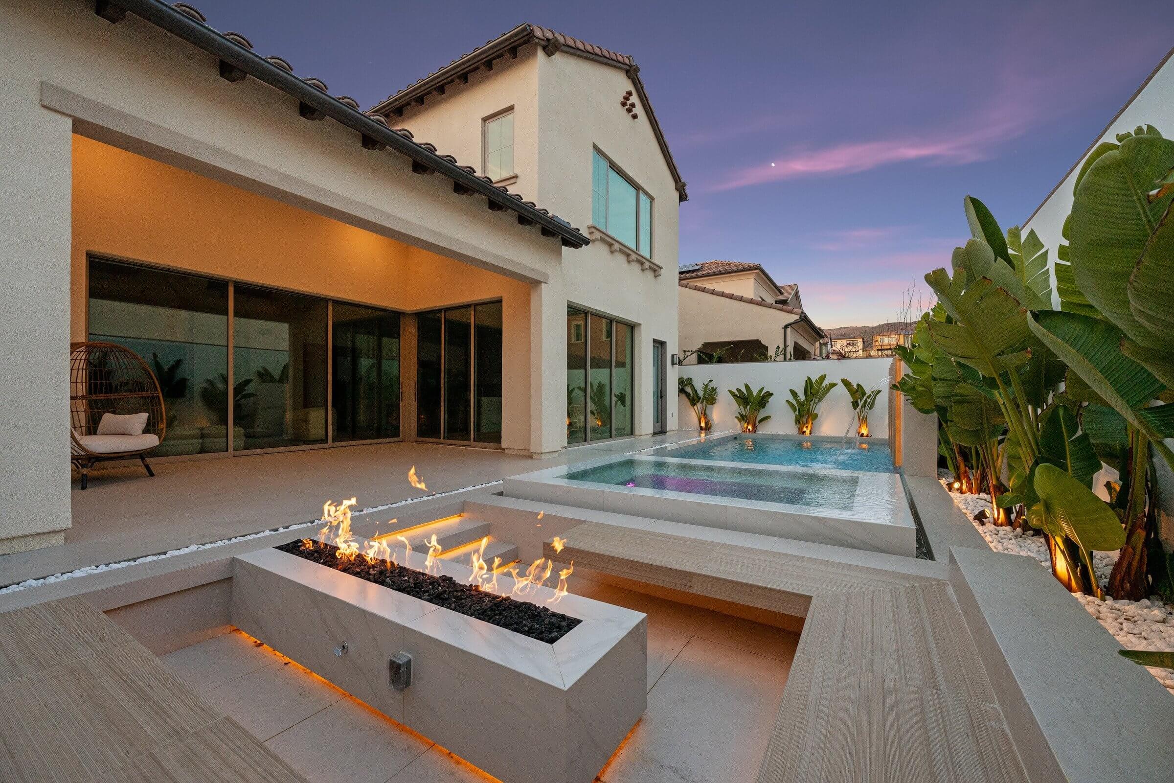 Custom outdoor patio with pool and fire feature by Oak and Anchor Builders